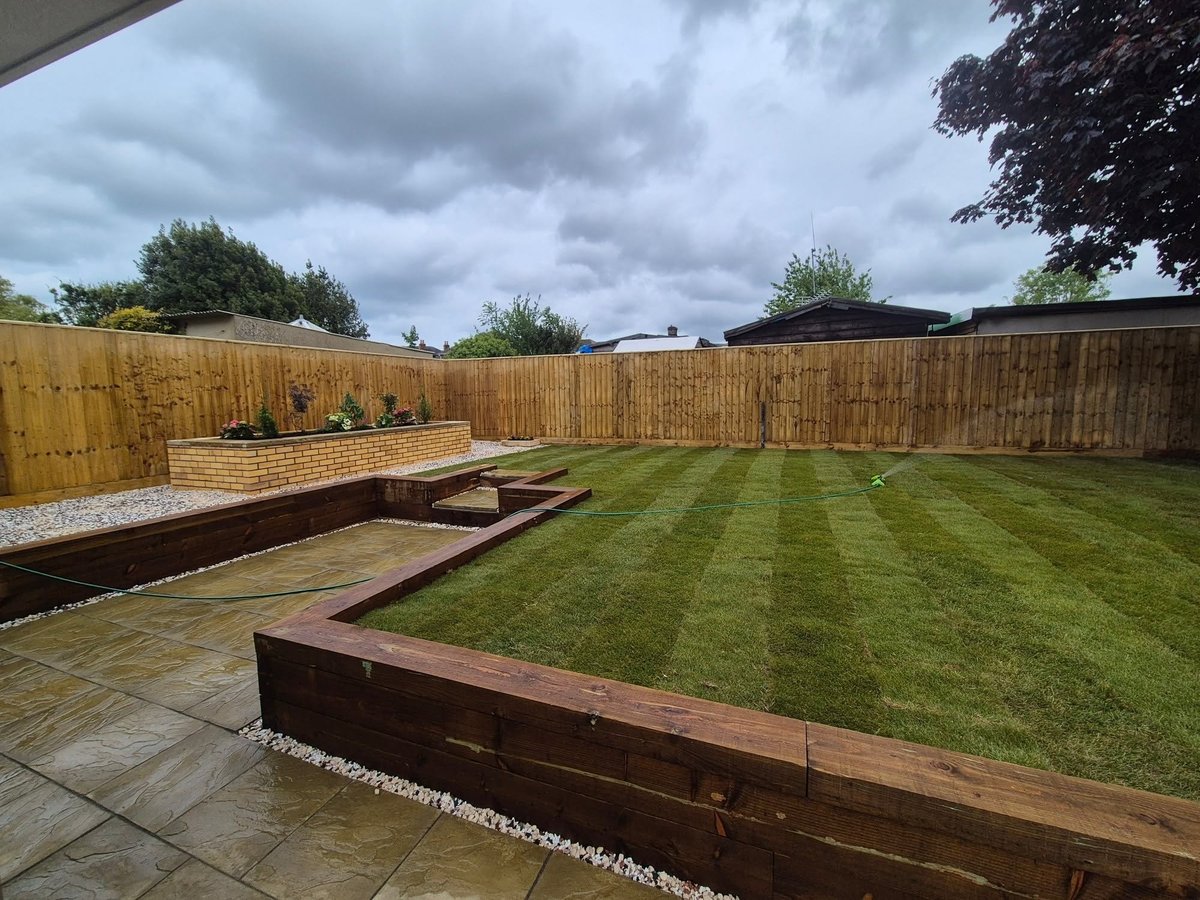 Completed — striped lawn, raised beds, and patio area